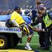 Milton Carhtens sits in the back of an ambulance vehicle as emergency personnel hold his leg after hurting his knee during the Victors Classic alumni football game at Michigan Stadium on Saturday. Melanie Maxwell I AnnArbor.com